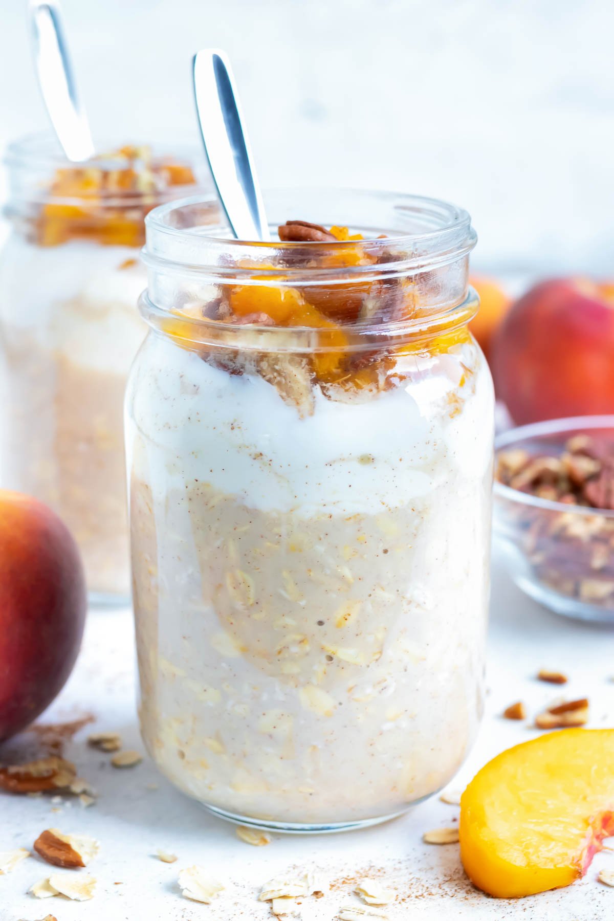 Oatmeal, yogurt, fresh peaches, and toasted pecans are combined in a mason jar for this easy overnight oats recipe.