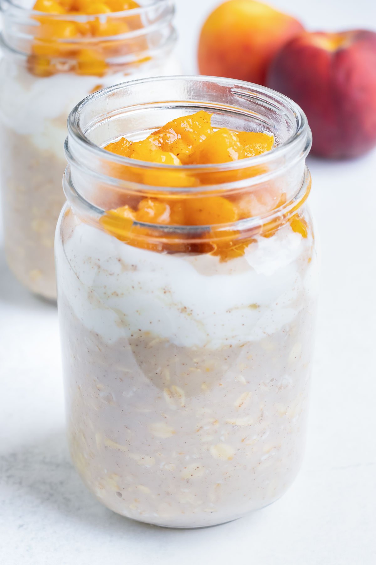 Chopped and cooked peaches are added to the oatmeal jar.