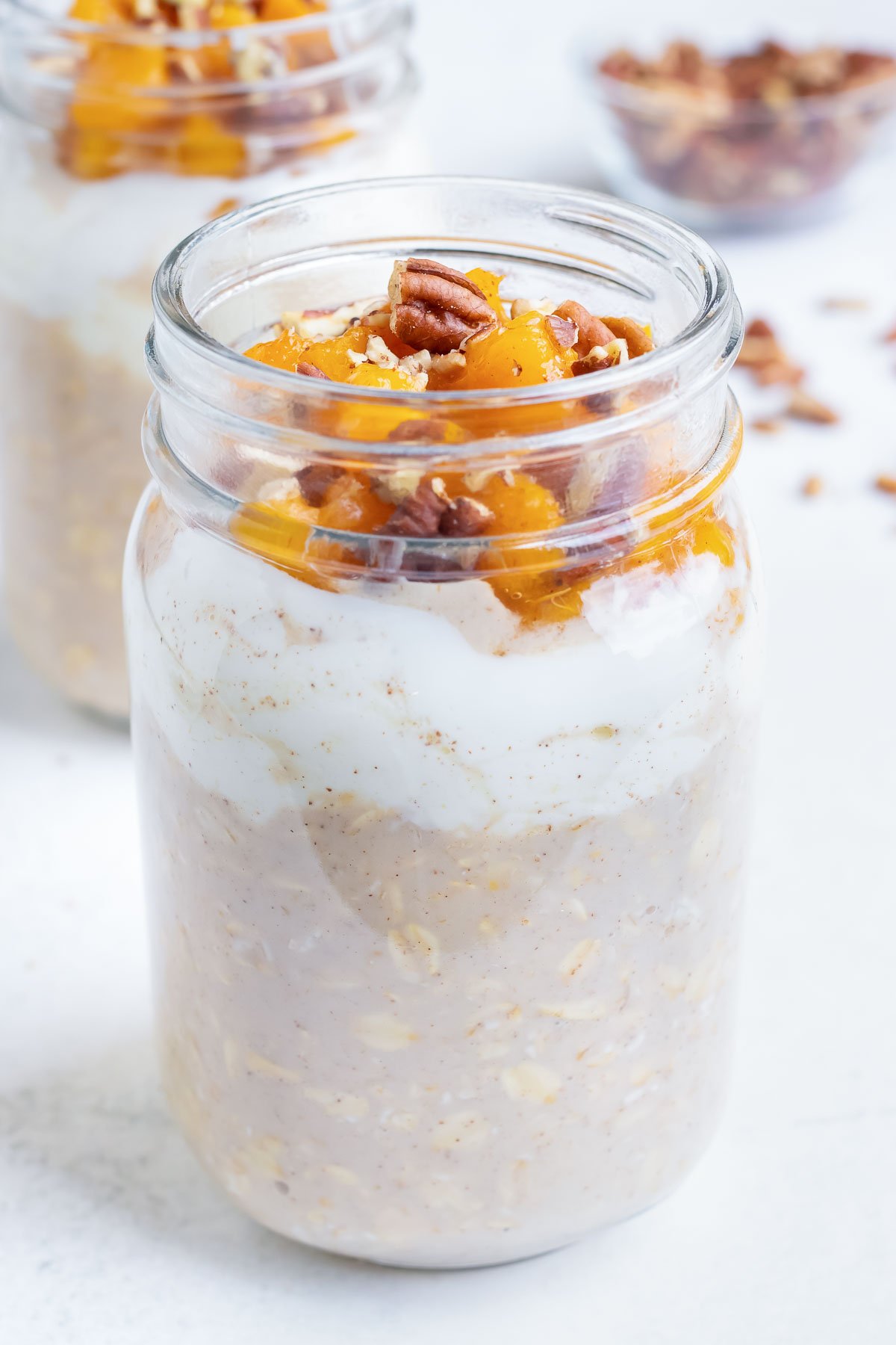 Meal prep overnight oatmeal for the week by combining milk, oats, yogurt, and peaches in a mason jar.