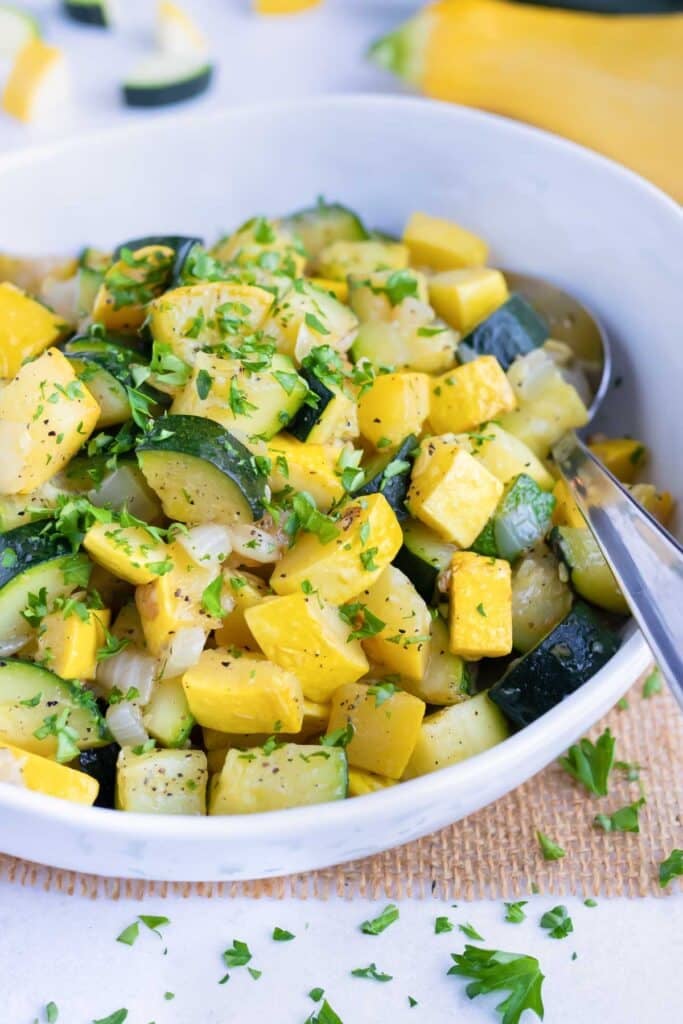 Cooked zucchini and squash with parsley sprinkled on top.