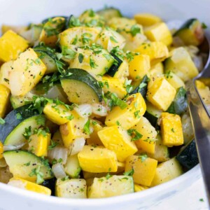 Cooked zucchini and squash with parsley sprinkled on top.