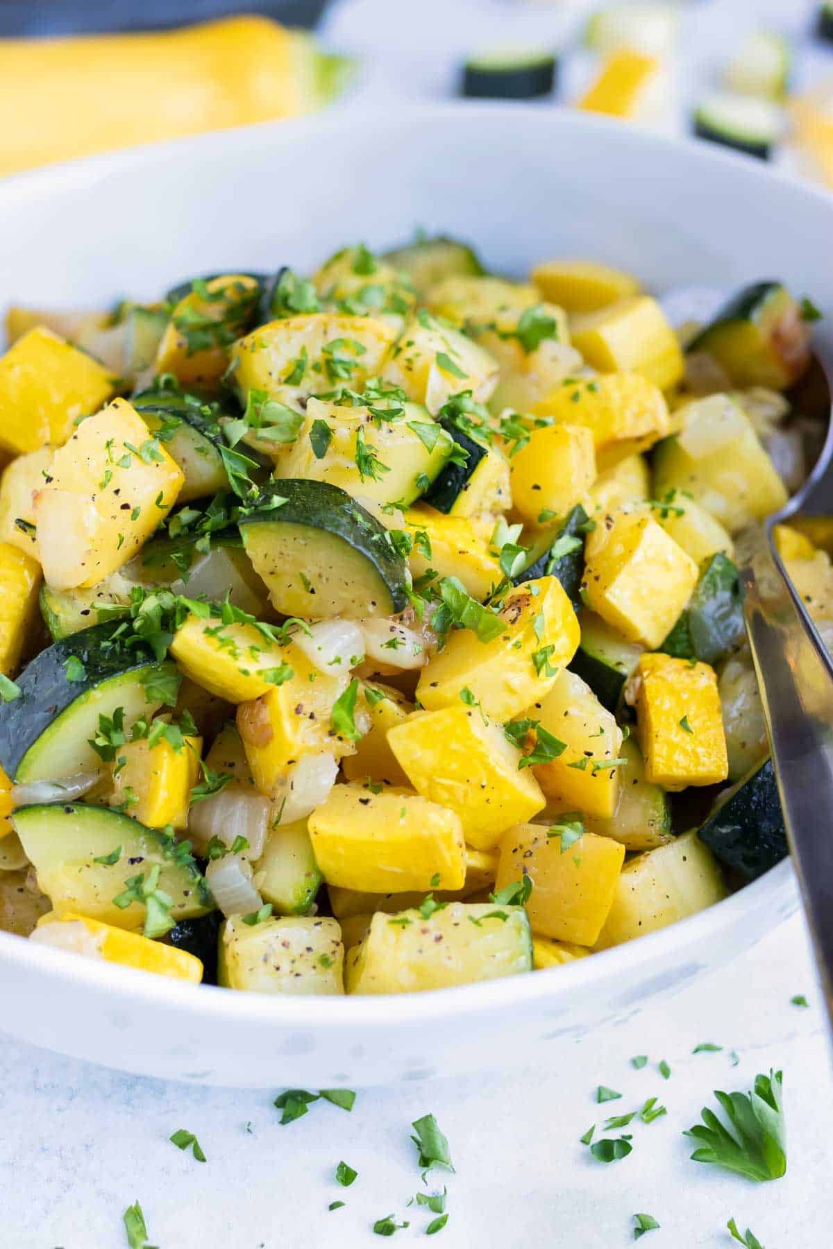 Cooked zucchini and squash with parsley sprinkled on top.