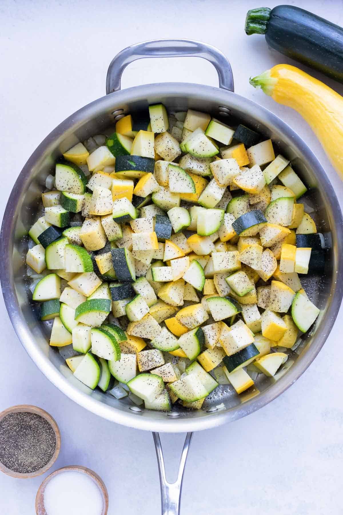 Zucchini and squash are added to the skillet.