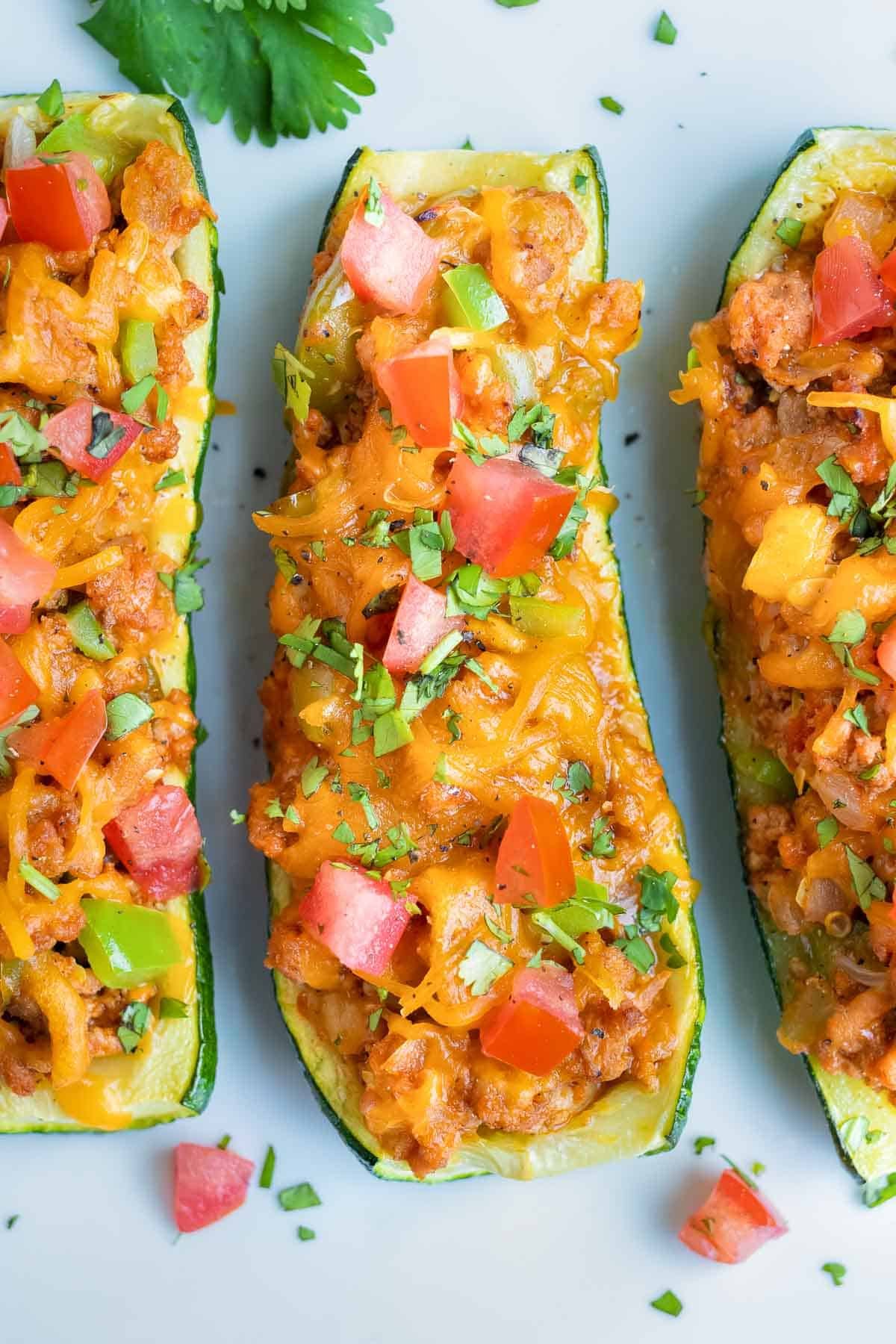 A row of taco stuffed zucchini boats on a dinner platter.