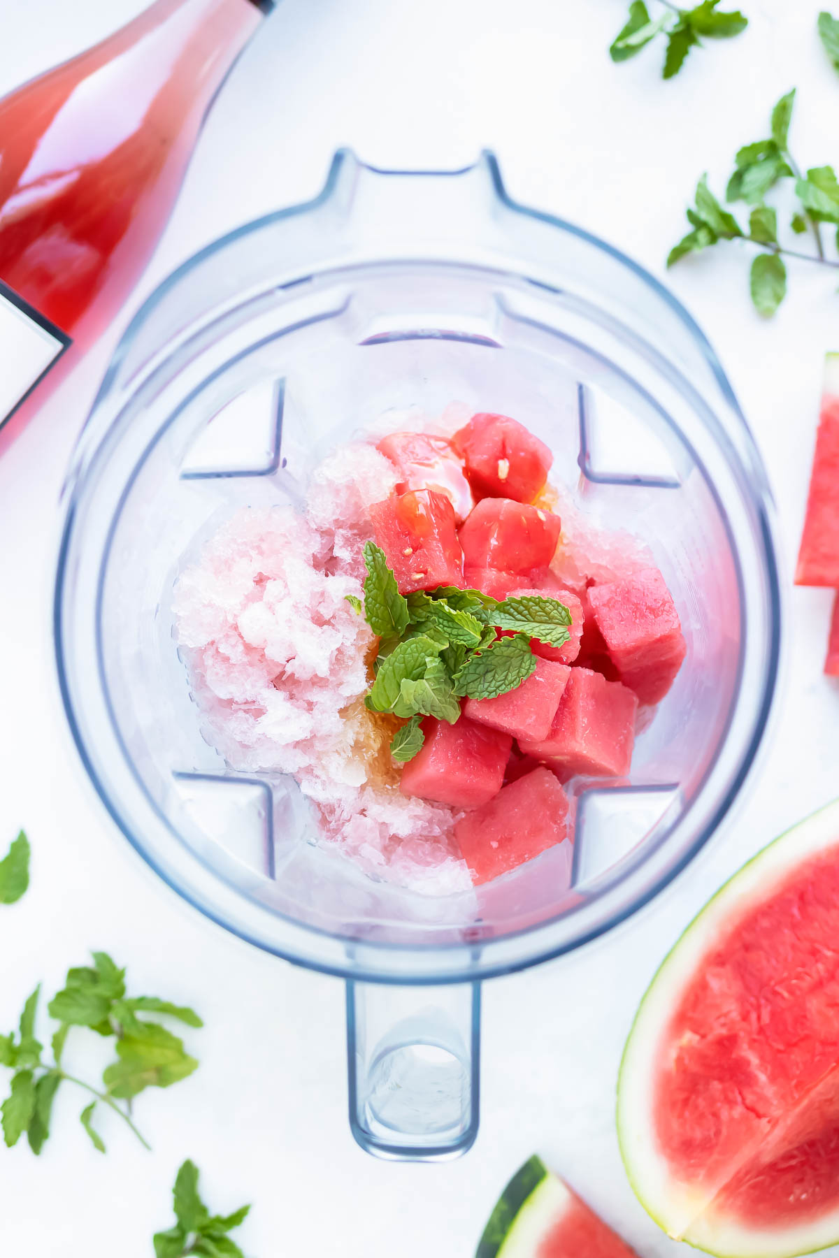 A vitamix full of frozen watermelon, rose wine, and mint.