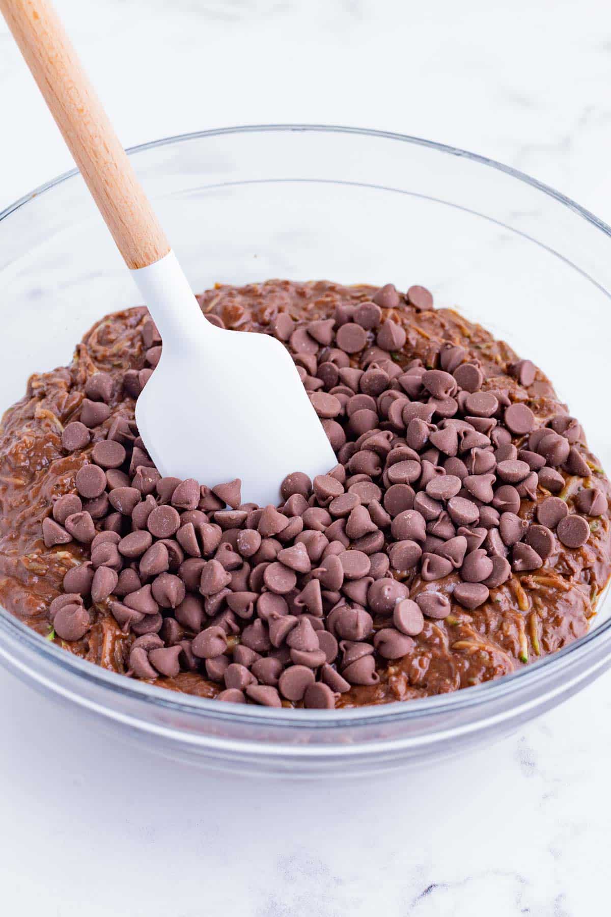 Chocolate chips are stirred into the brownie batter.