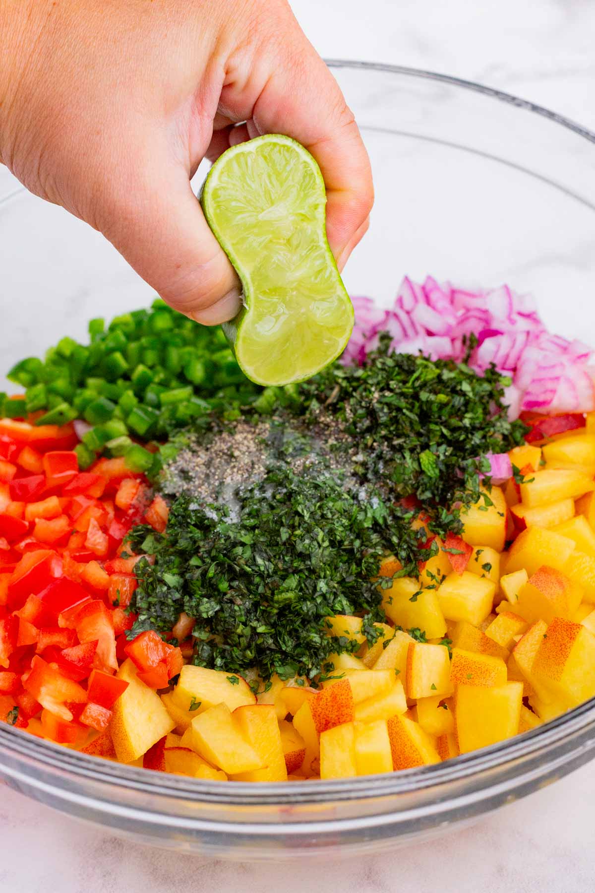 Lime juice is squeezed over the salsa ingredients.
