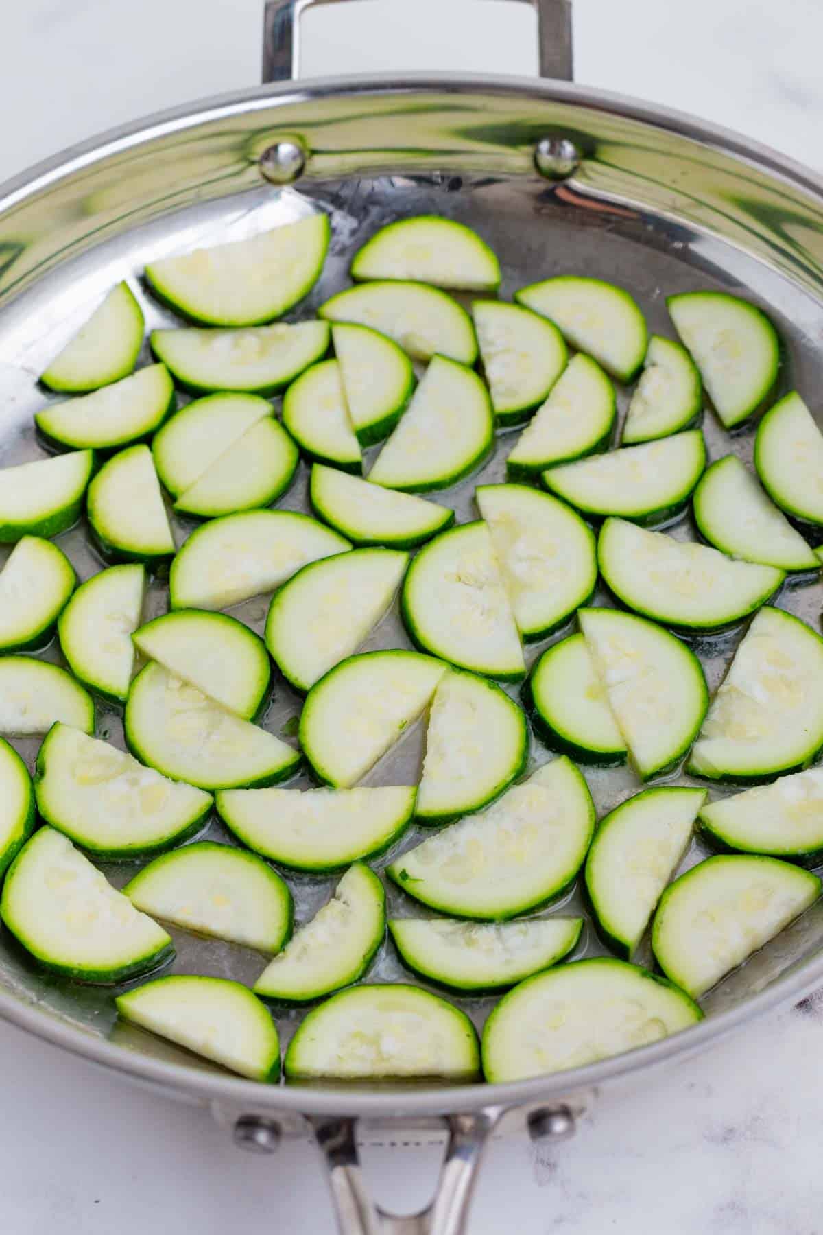 Sliced zucchini is added to a hot skillet.