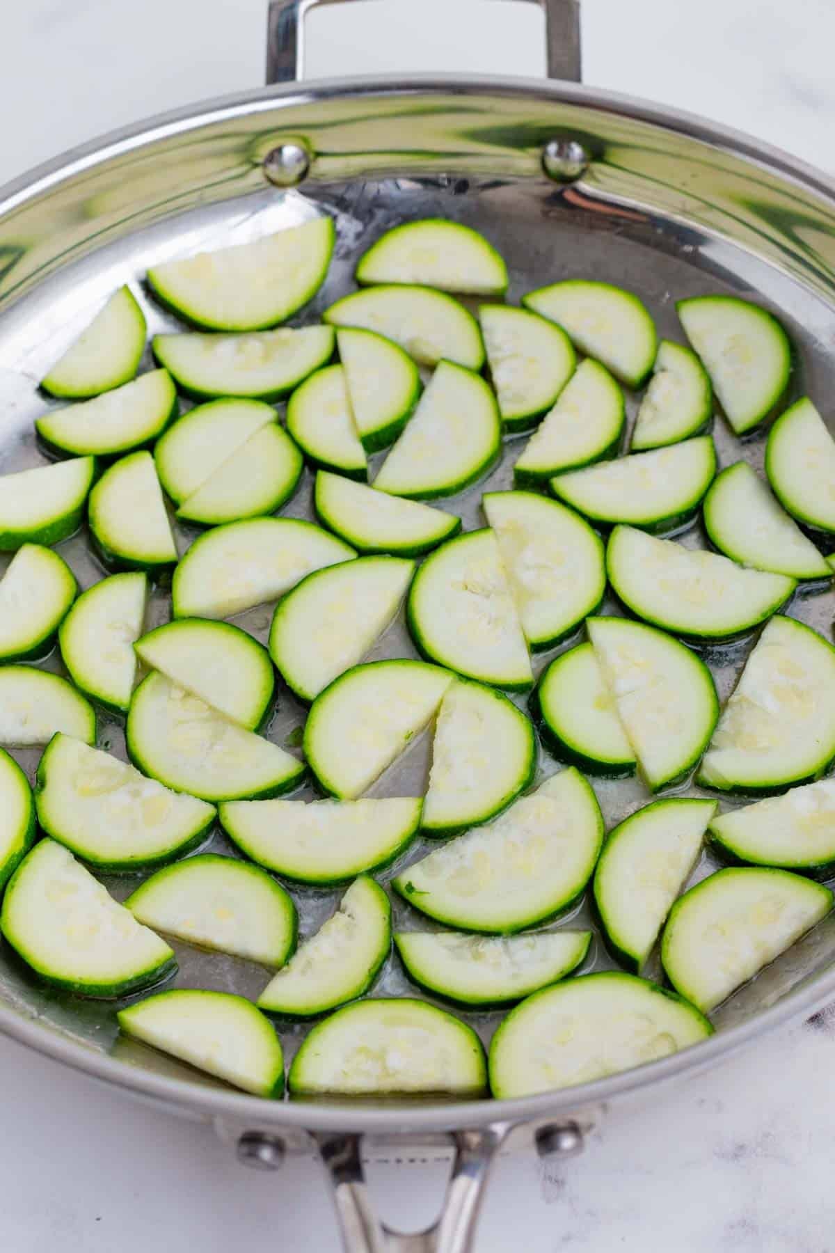 Cut halved zucchini in a frying pan.