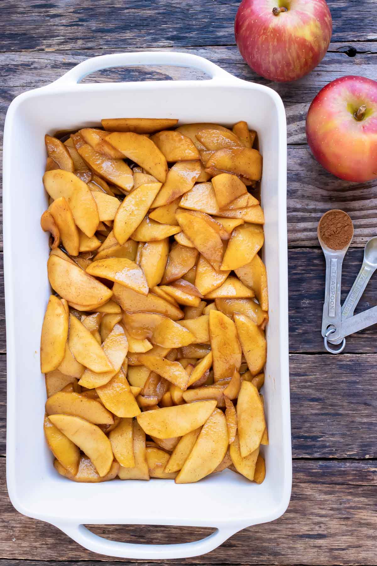 Apples are added to the baking dish.