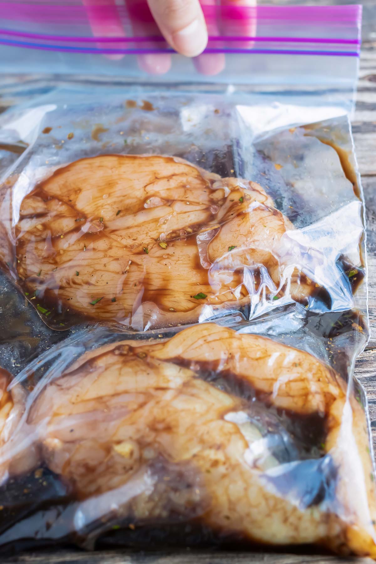 Chicken breasts soaking in a balsamic marinade before cooking.