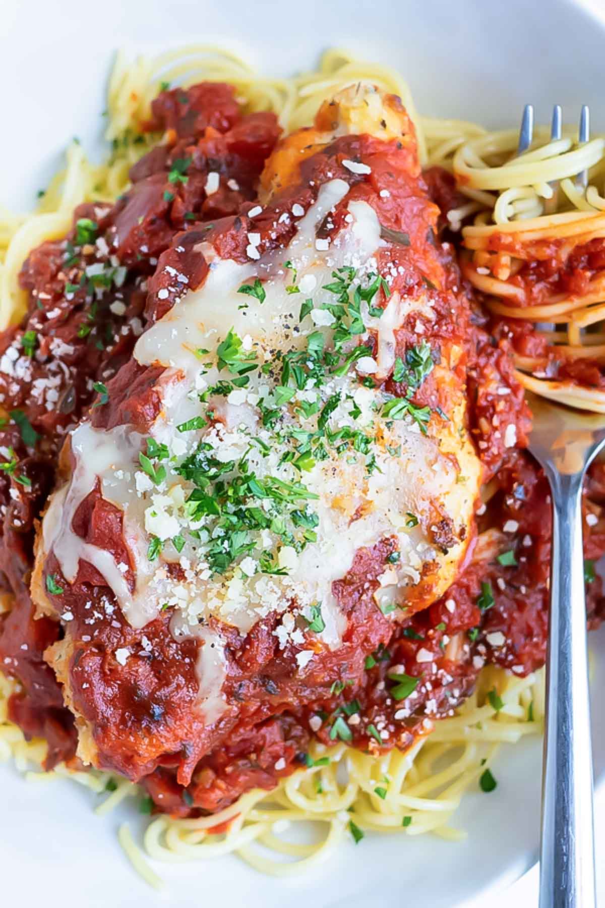 The best chicken parmesan recipe is served over pasta for a healthy dinner.