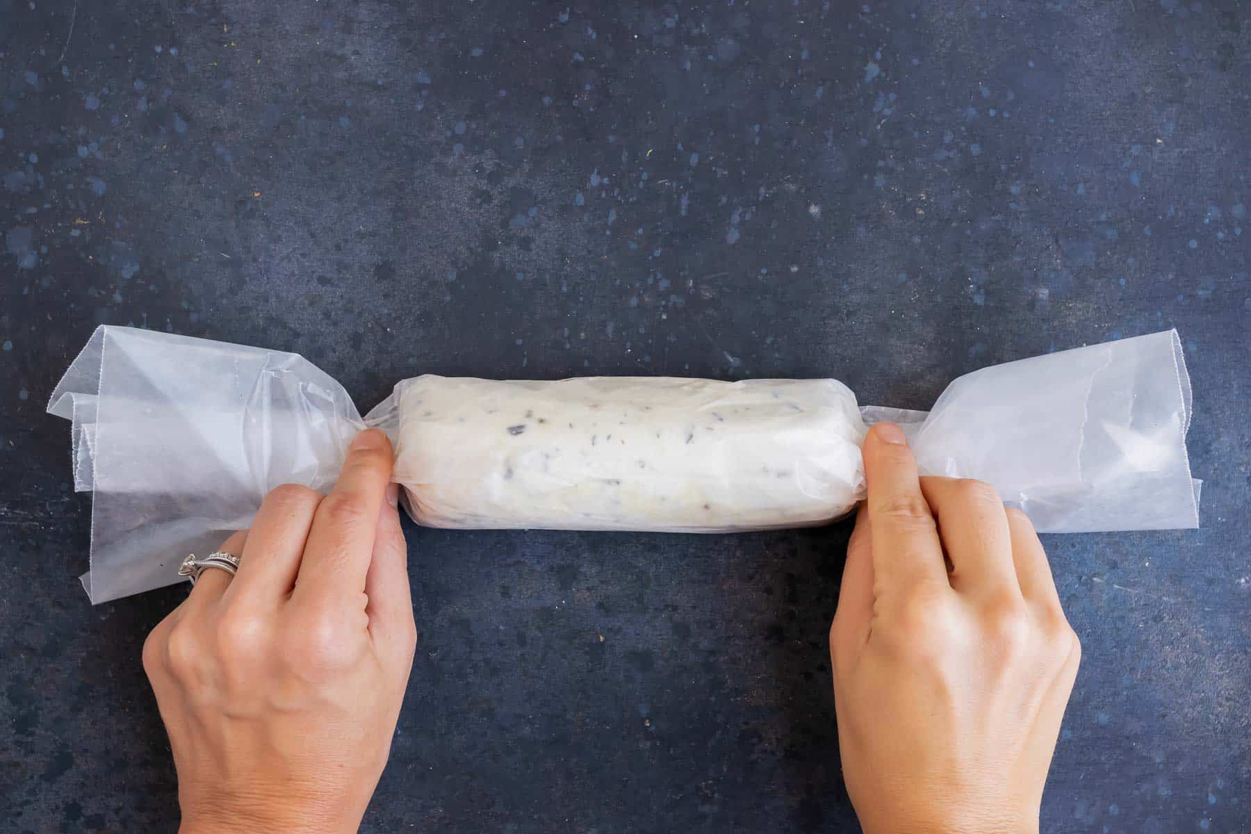 The goat cheese log is wrapped in wax paper.
