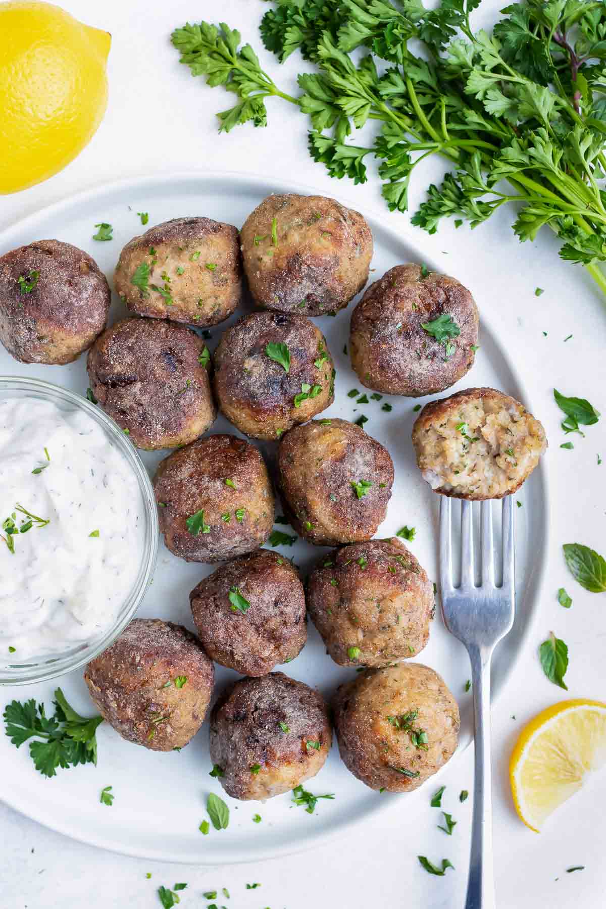 Greek Turkey Meatballs are placed on a plate with a Tzatziki dipping sauce.