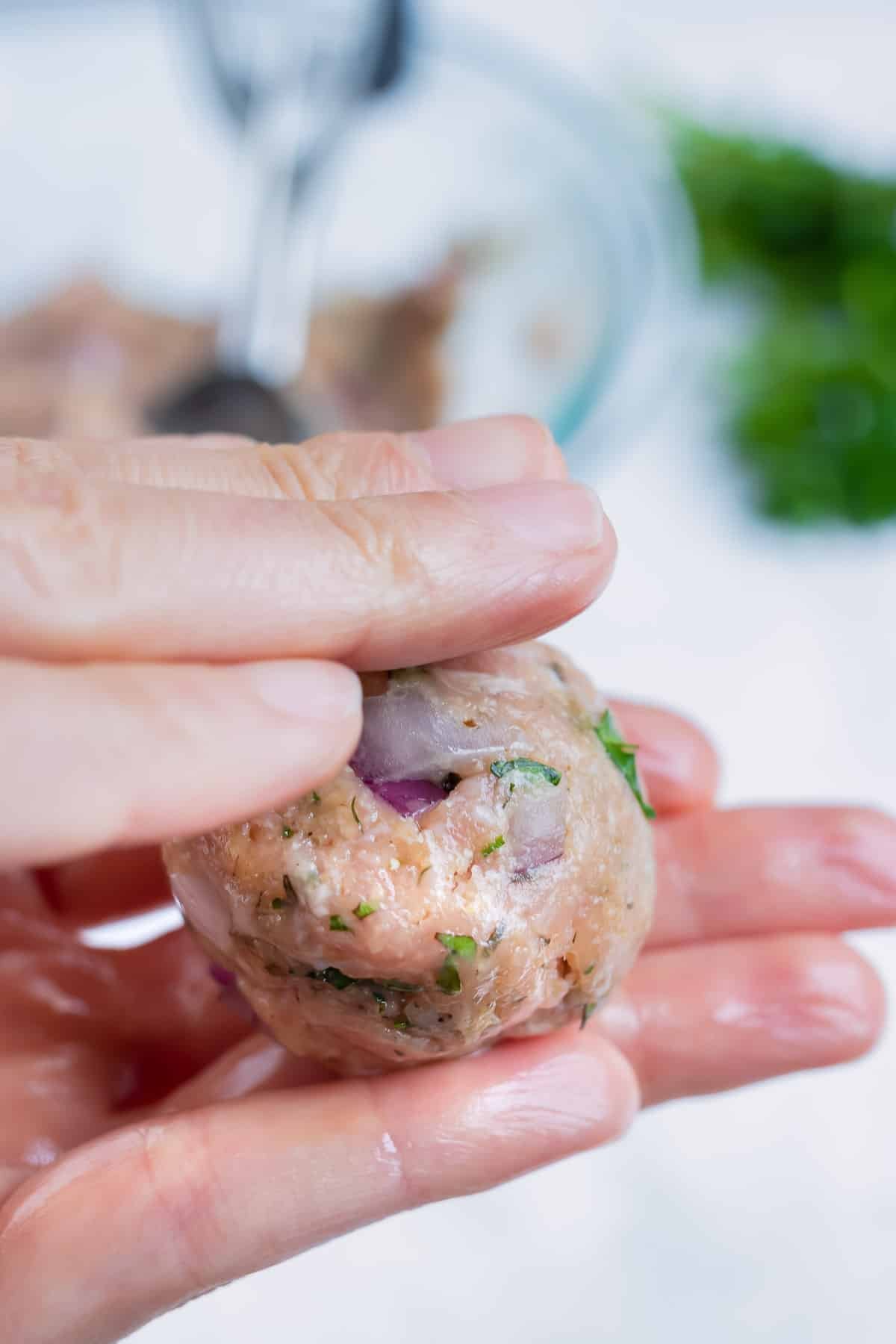 Greek turkey meatballs are rolled into balls before being cooked.