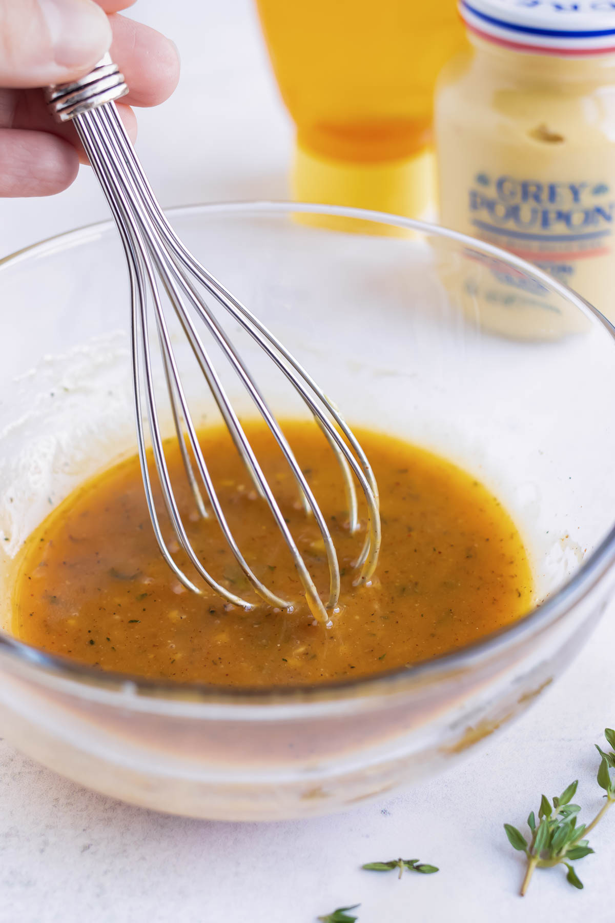 Honey mustard sauce being whisked together in a bowl.