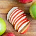 Fresh apple slices are laid on the counter before adding to apple pie or oatmeal.