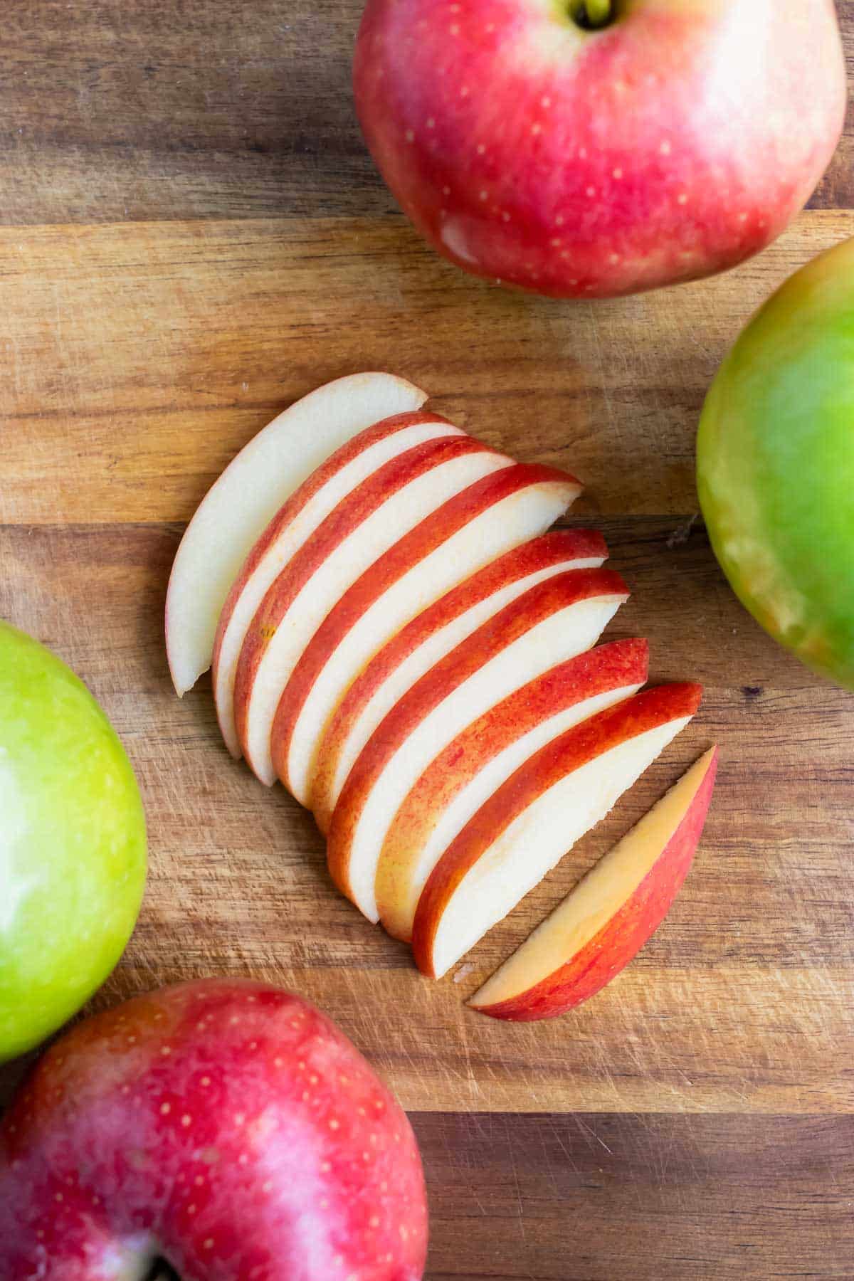 Fresh apple slices are laid on the counter before adding to apple pie or oatmeal.