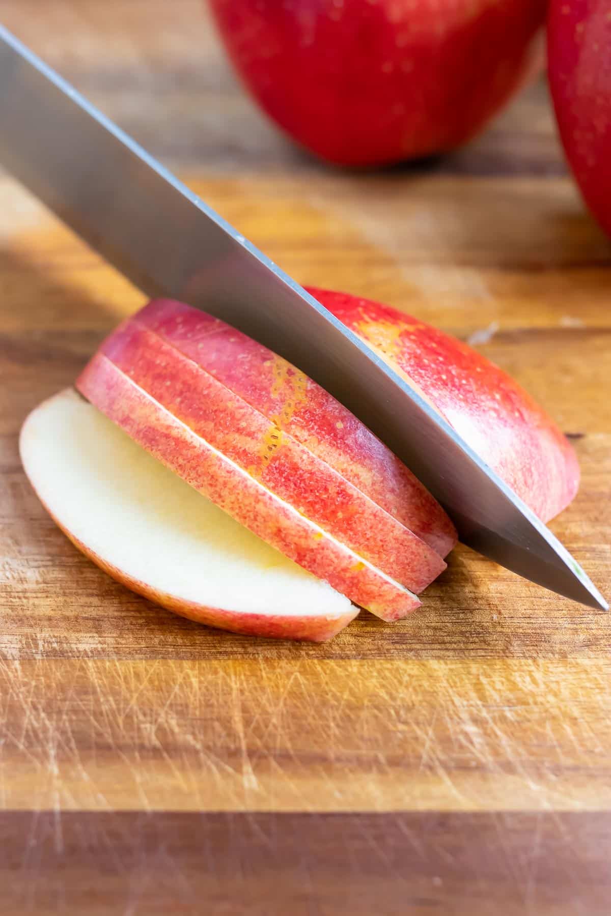 Lay the apple flat on the cutting board and then cut the apple into similar sized slices.