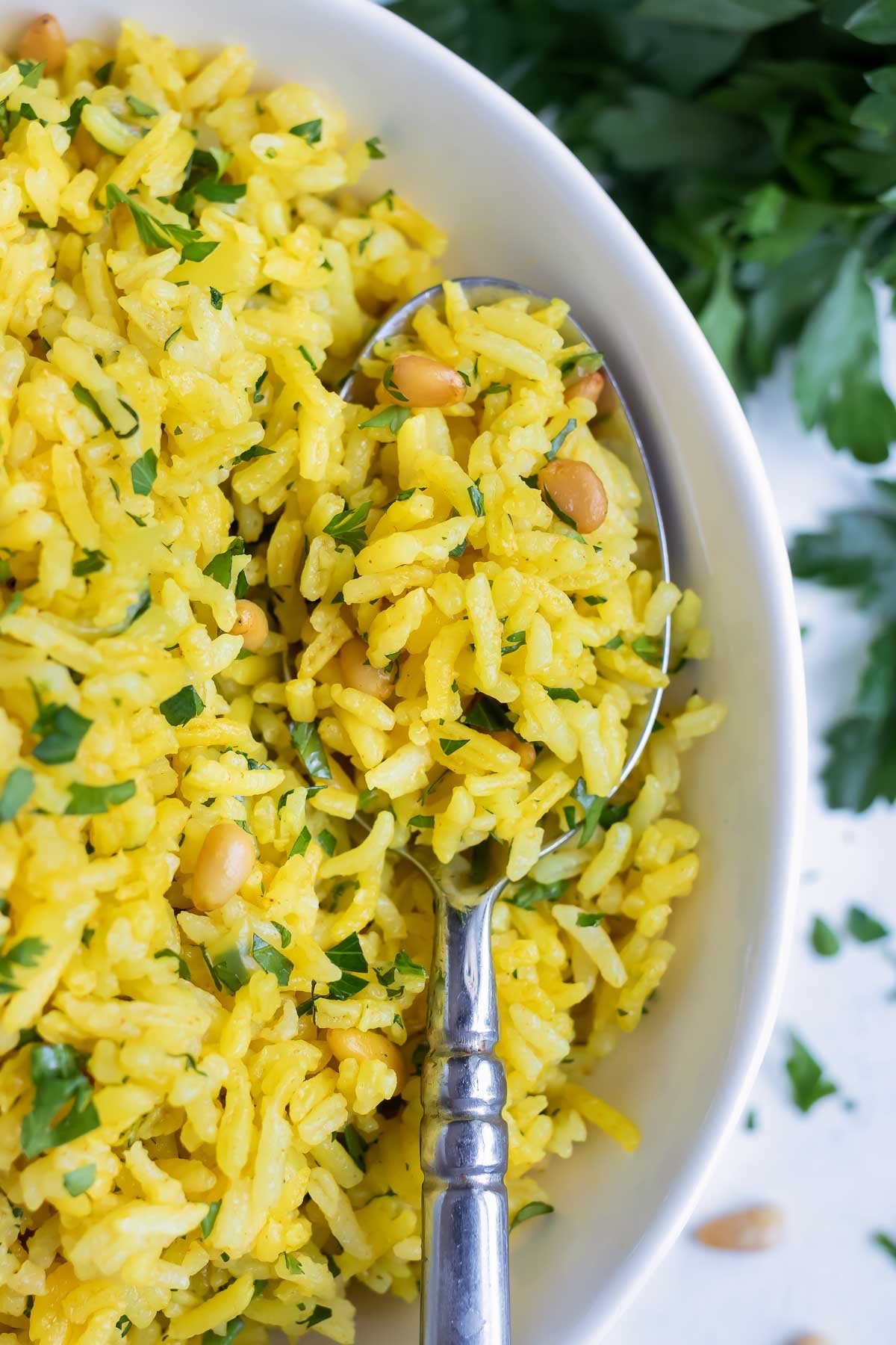 Yellow rice is served with a metal spoon.