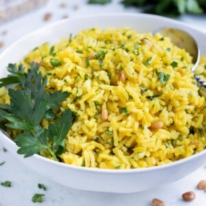 Mediterranean Yellow Rice is served from a bowl on the counter.