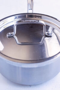 A pot full of Mexican rice is covered and simmered.