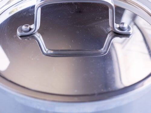 A pot full of Mexican rice is covered and simmered.