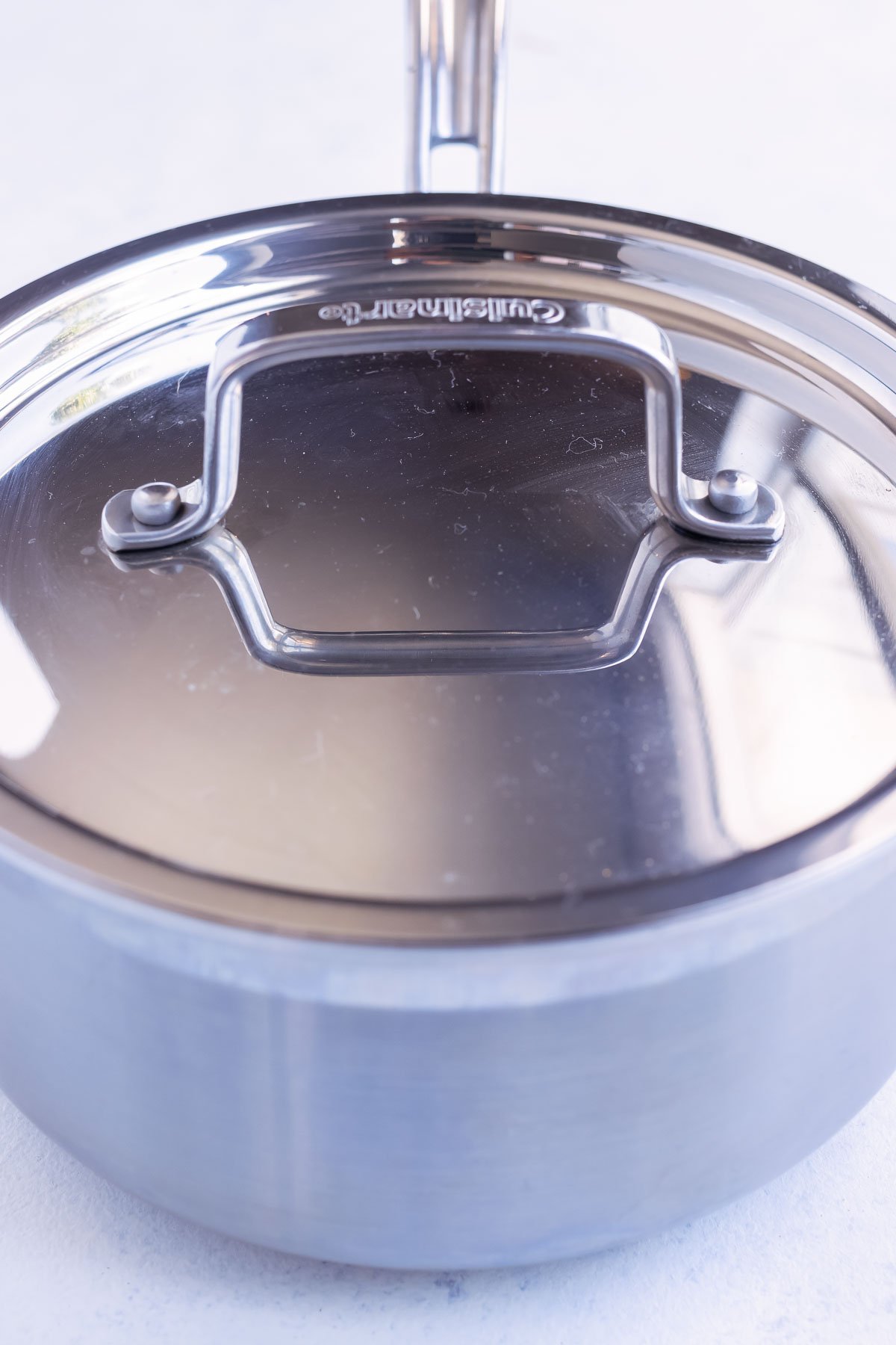 A pot full of Mexican rice is covered and simmered.