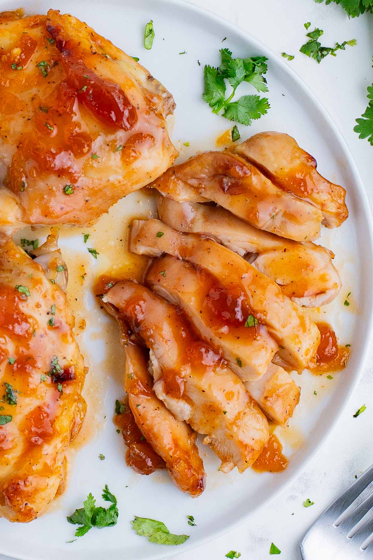 Chicken thighs cooked in an apricot sauce are sliced before serving.
