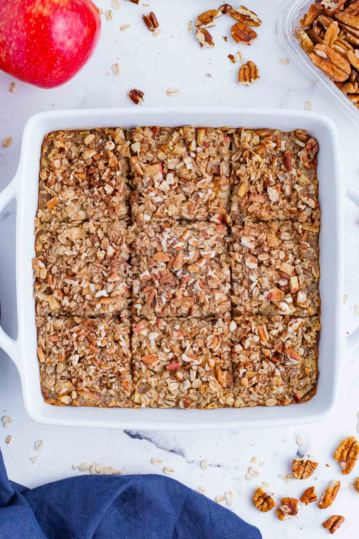 A pan of baked apple oatmeal is sliced into 9 servings.