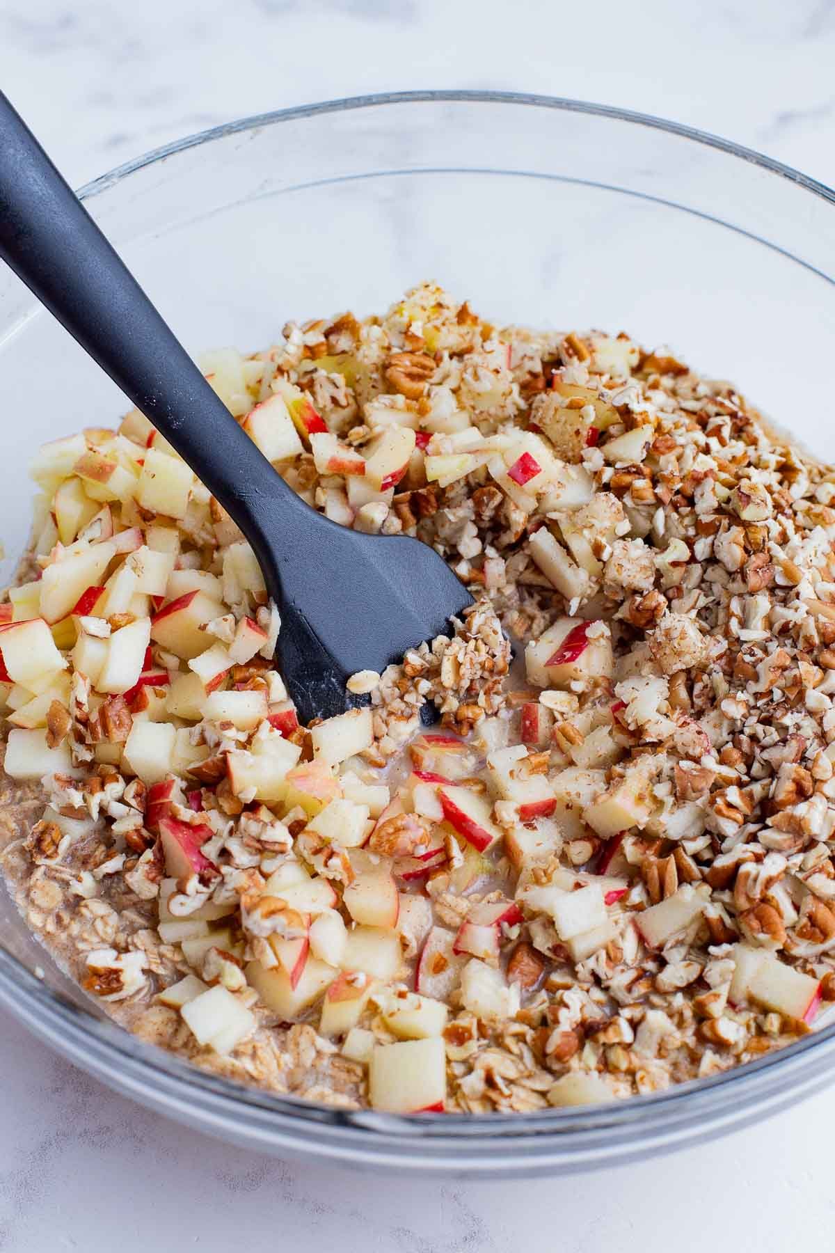 Apples are stirred into the oatmeal mixture.