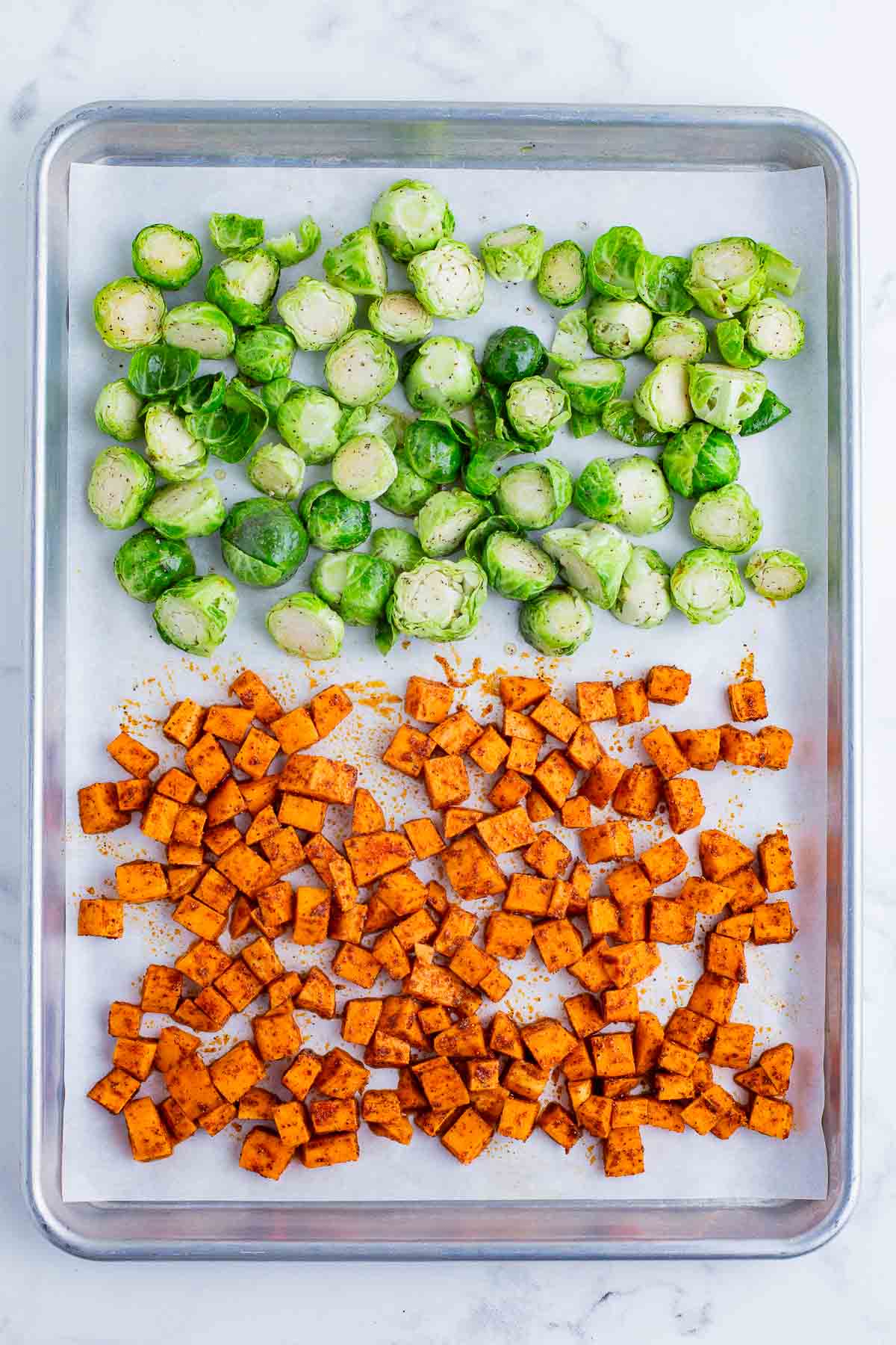 Sweet potatoes and Brussels sprouts are baked in the oven.