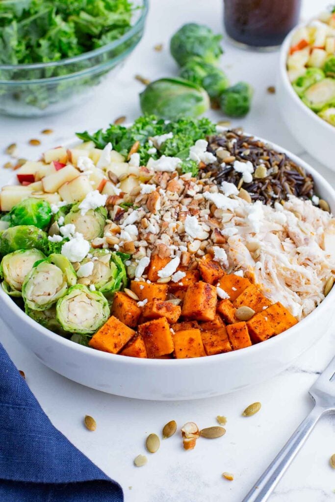 Healthy chicken and veggies are served on top of rice with a balsamic dressing.