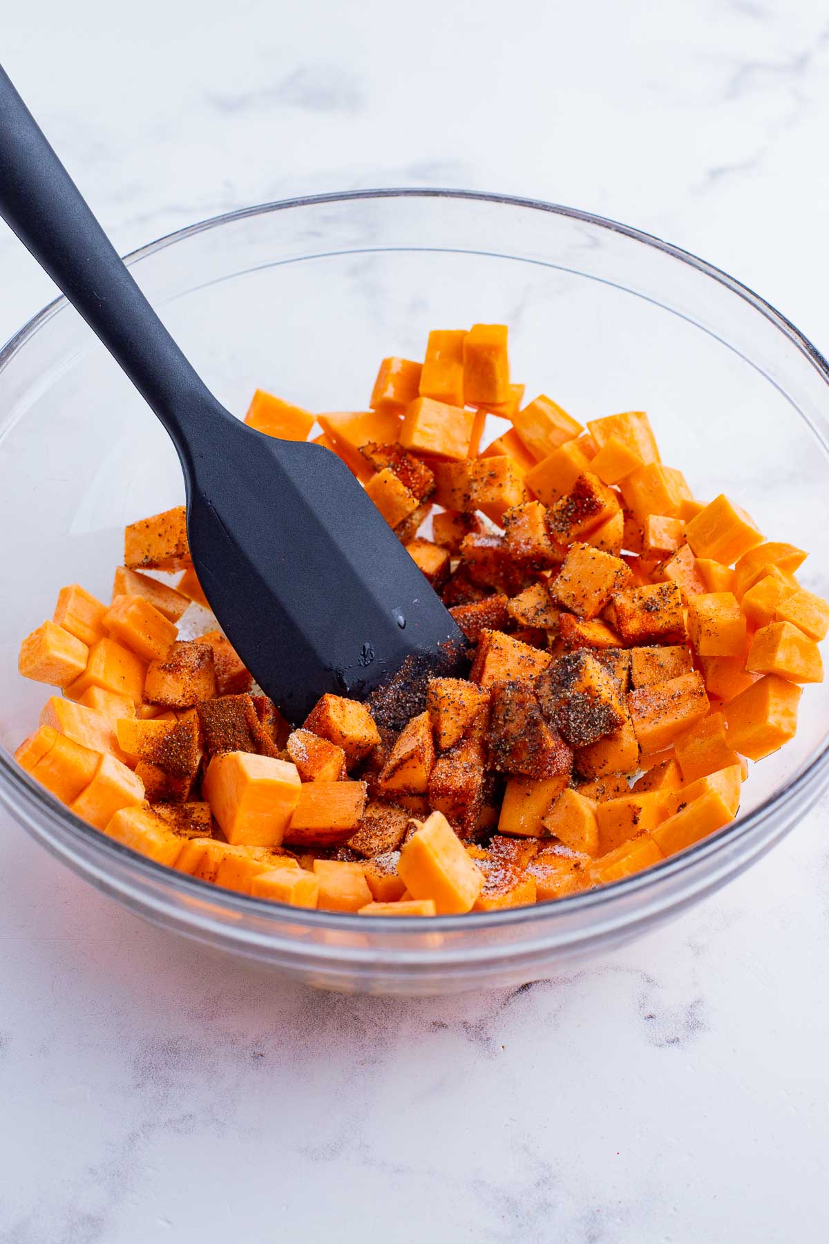 Sweet potatoes are seasoned before baking.