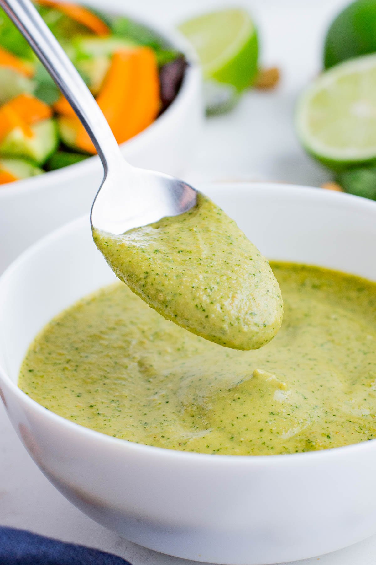 A spoonful of Spicy Cashew Dressing from a white bowl.