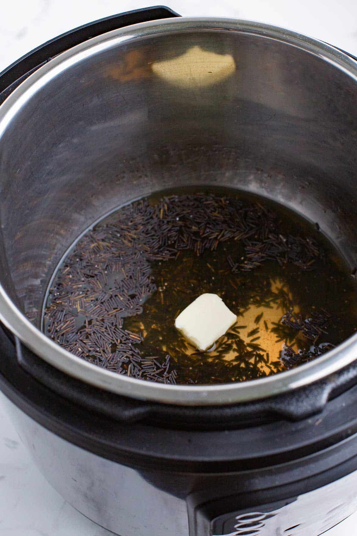 Add the liquid, butter, and rice to the Instant Pot.