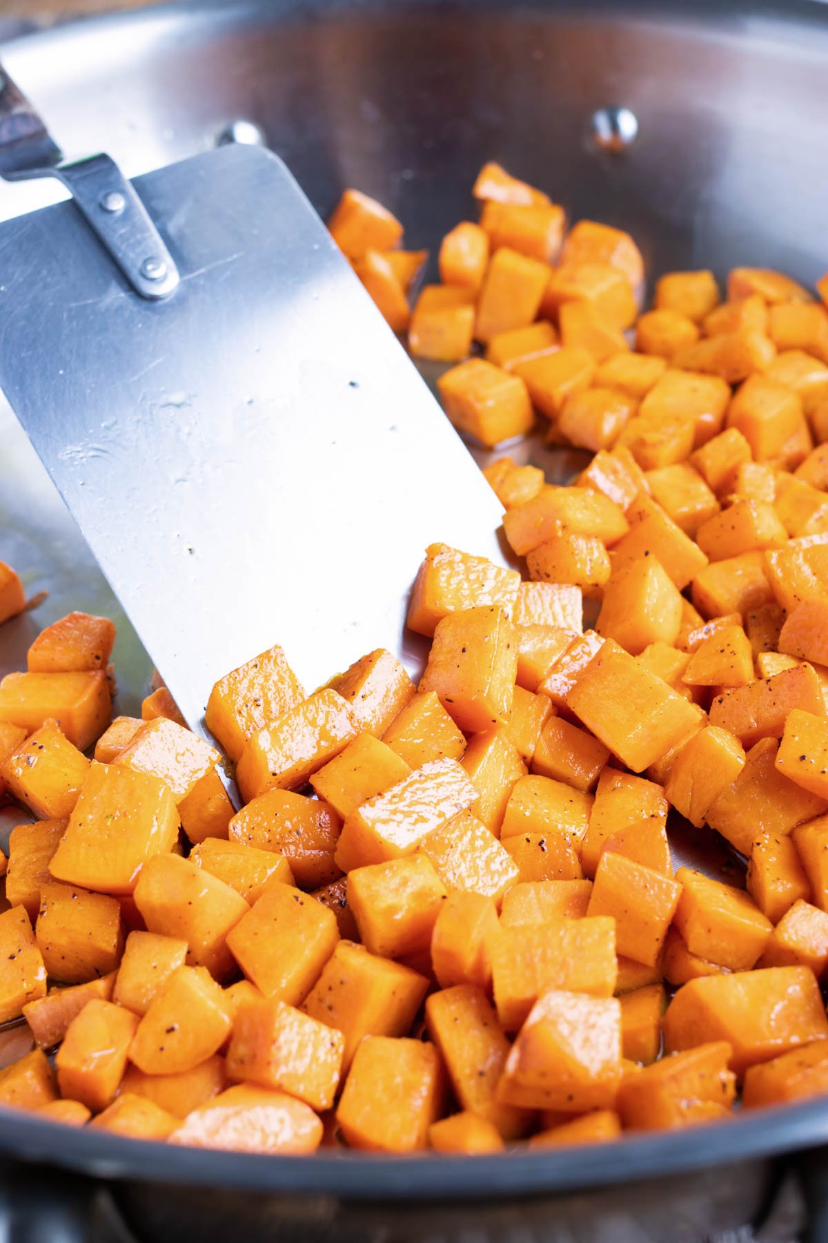 Sweet potatoes are cooked in a skillet.