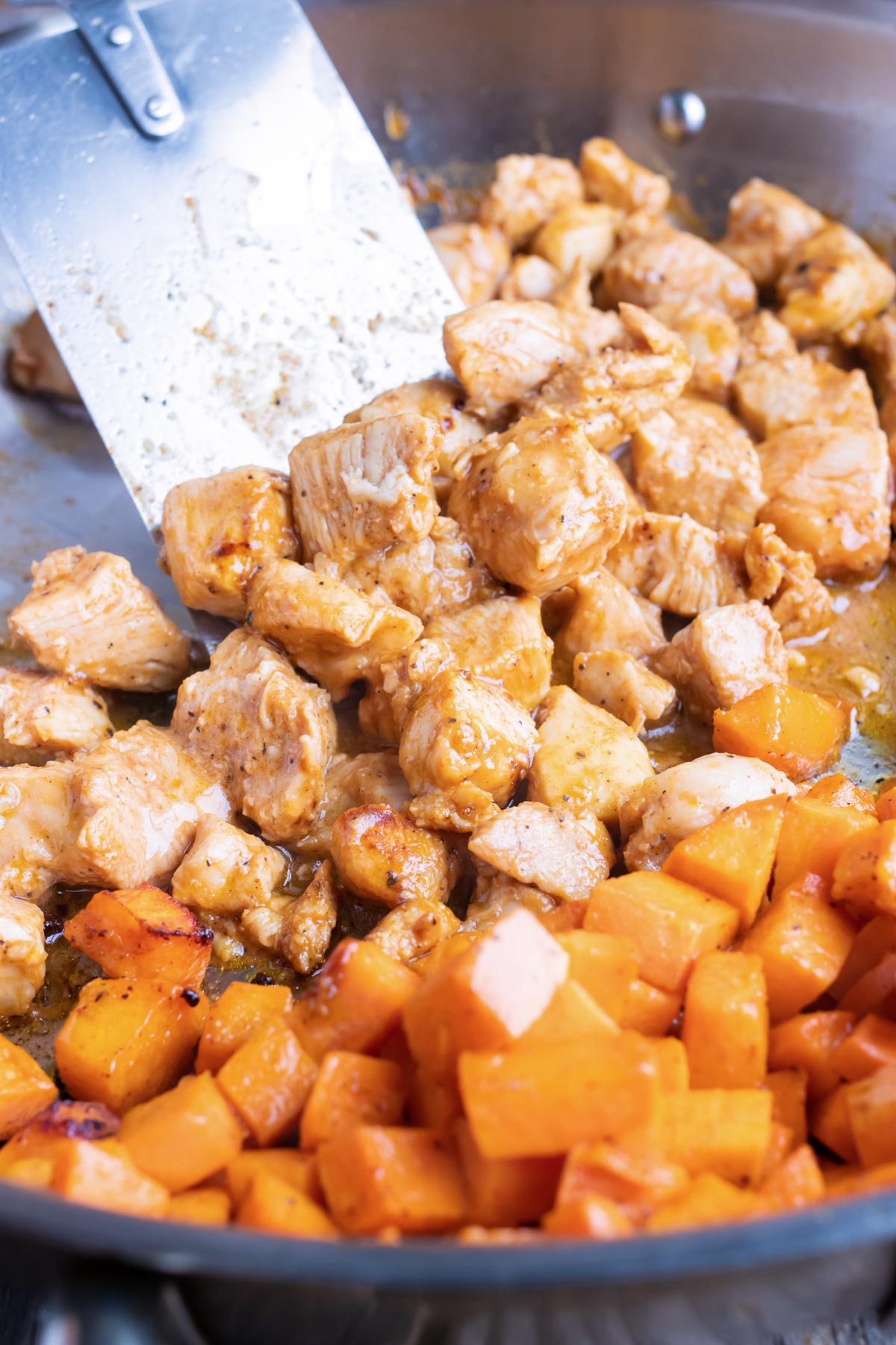 Chicken is added to the sweet potatoes in the skillet.
