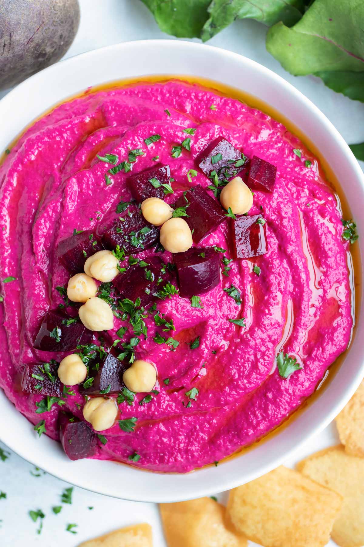 Roasted beet hummus is served in a bowl for dipping vegetables and crackers.