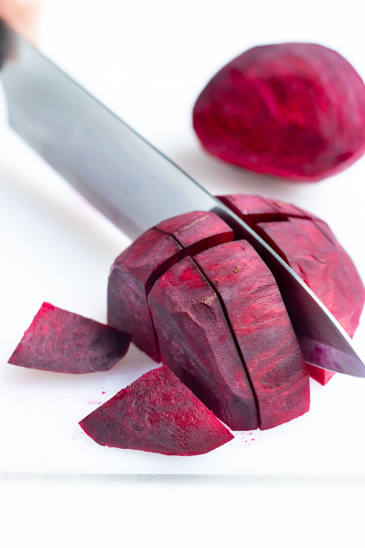 Peeled beets are sliced into chunks.