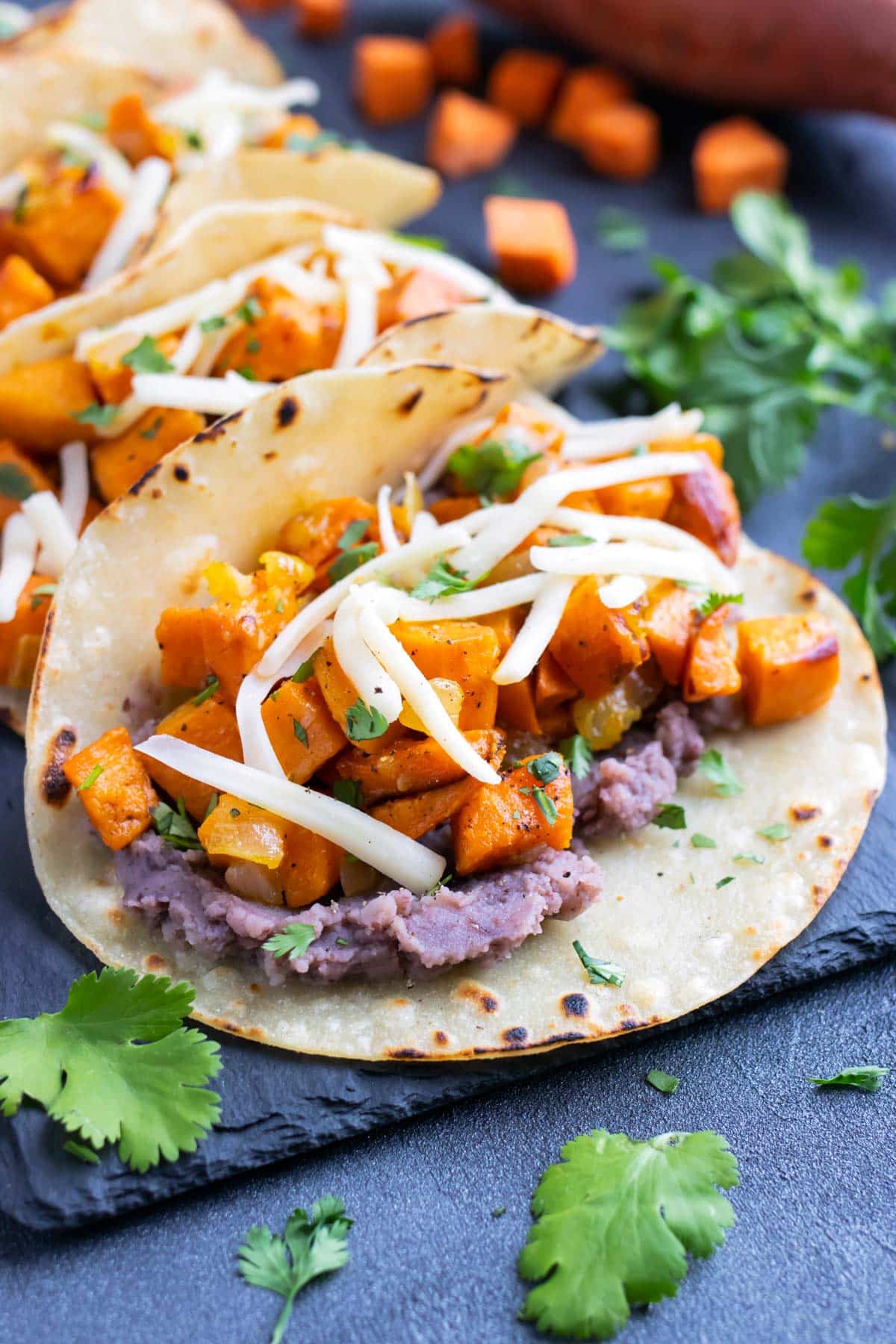 Vegetarian black bean sweet potato tacos with cheese in a corn tortilla.