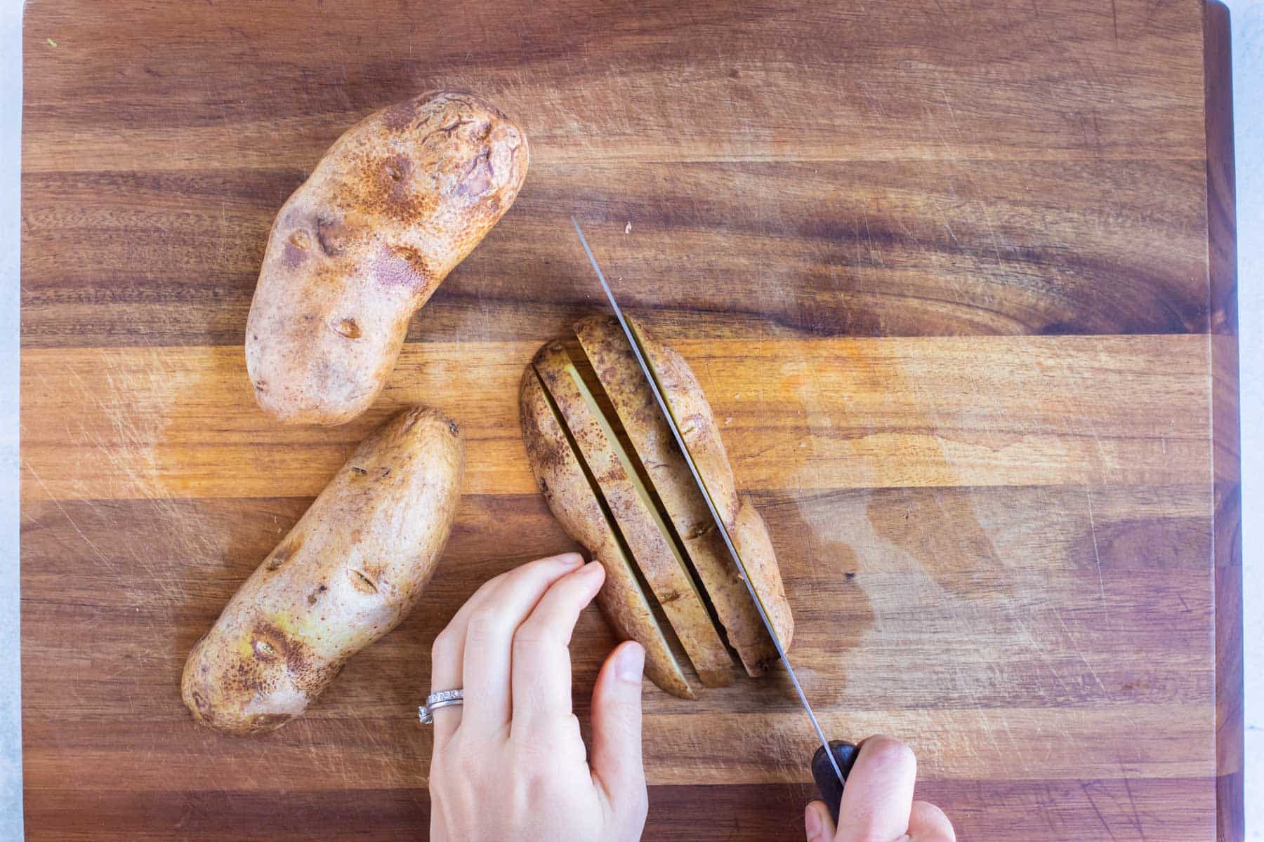 Potatoes are sliced into strips before being diced.