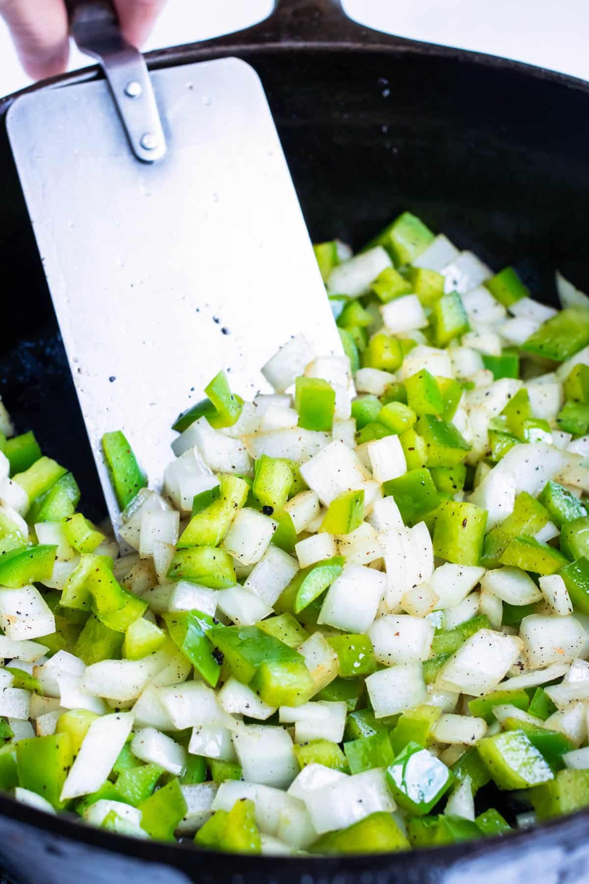 Peppers and onions are cooked in the bacon grease.