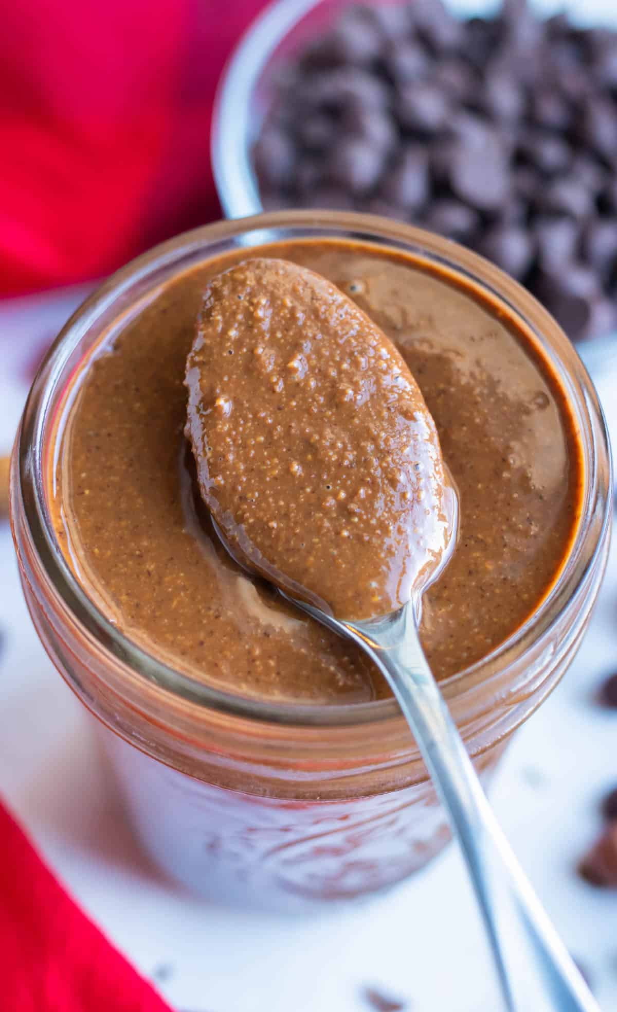 Homemade nutella is lifted up by a spoon for a healthy dessert spread.