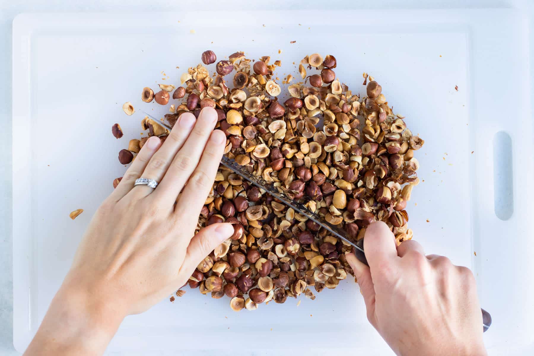 The roasted hazelnuts are chopped finely before blending.