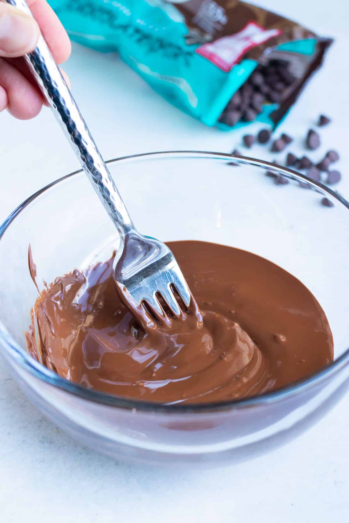 Chocolate chips are melted in a glass bowl before adding to this healthy nutella recipe.