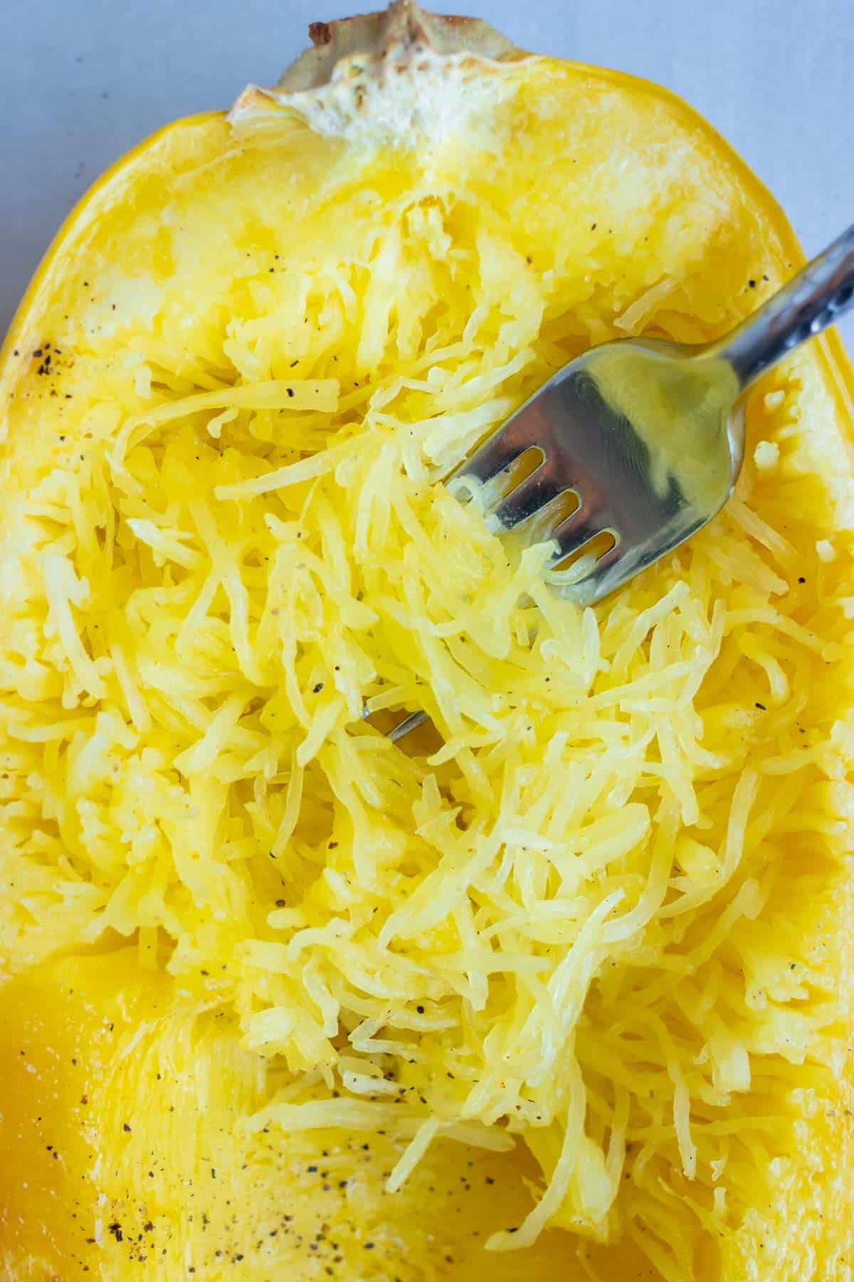 Spaghetti squash is shredded for a vegan or vegetarian dish.