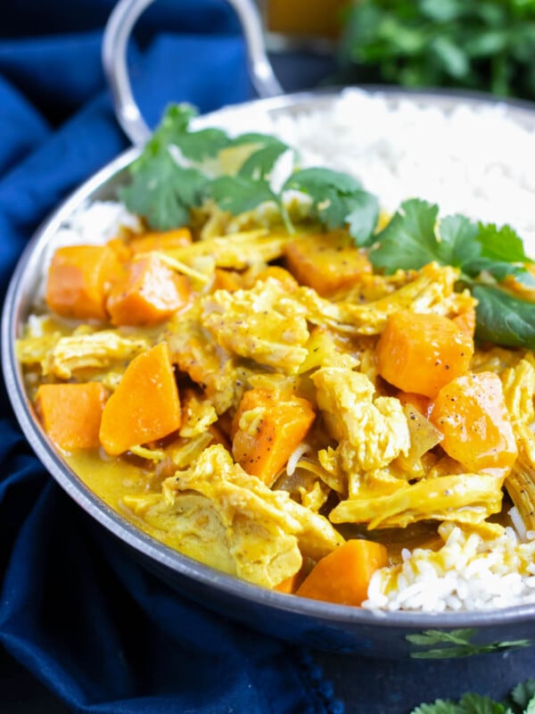 An easy chicken curry recipe with a yellow curry sauce that was made in the slow cooker and served with white rice and cilantro.