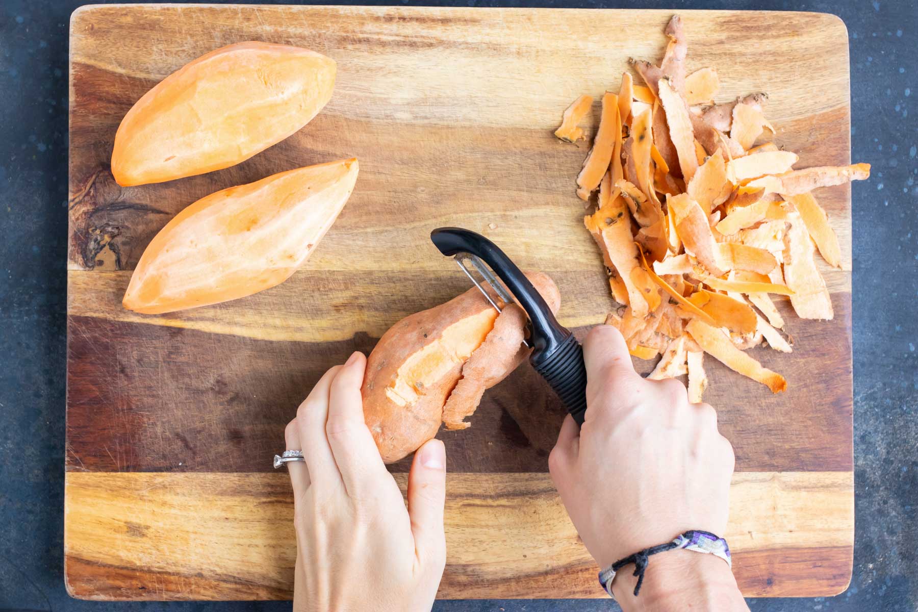 Sweet potatoes are peeled on a cutting board.