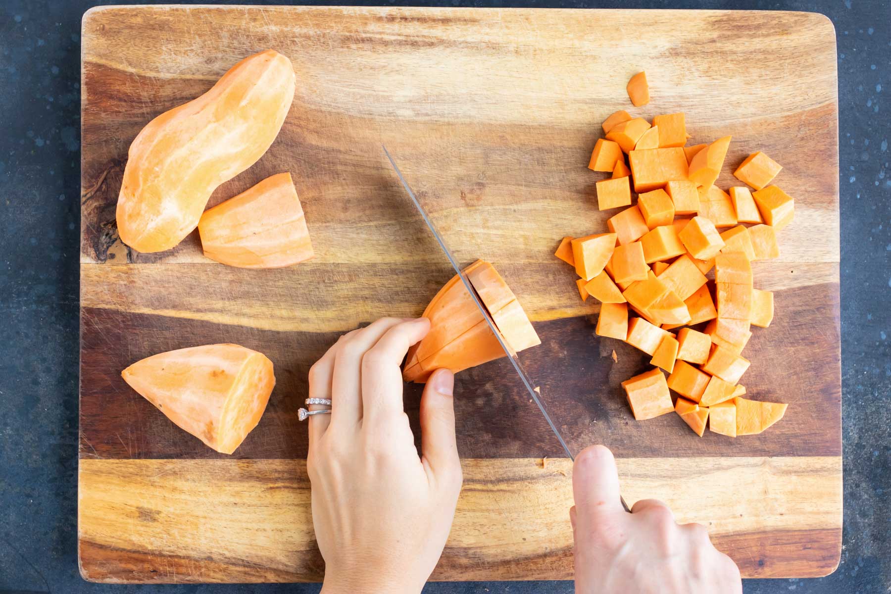 A peeled sweet potato is diced.